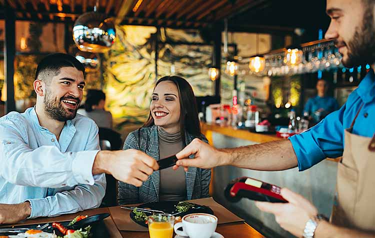 man paying with debit or credit card in restaurant