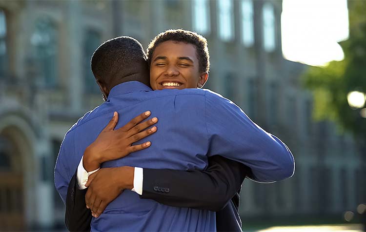 Graduate in regalia celebrating about to hug grandma