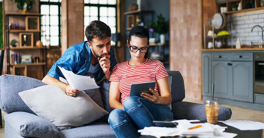 couple looking through bills, trying to get out of debt