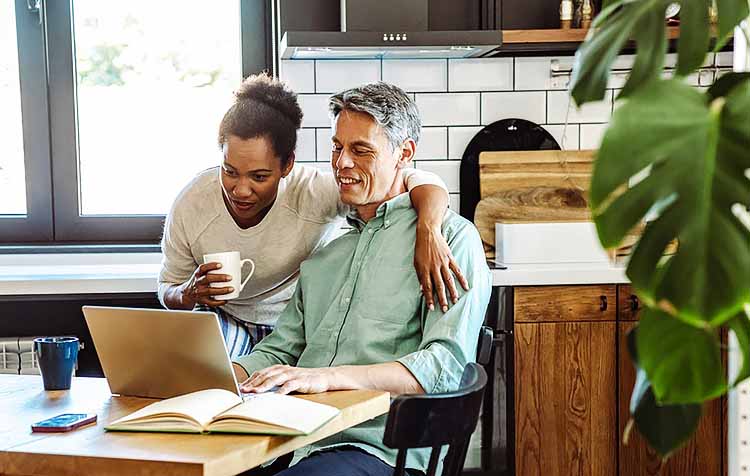 Couple looking at laptop in kitchen