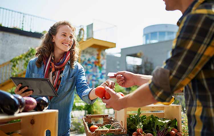 Person paying for produce at farmer's market