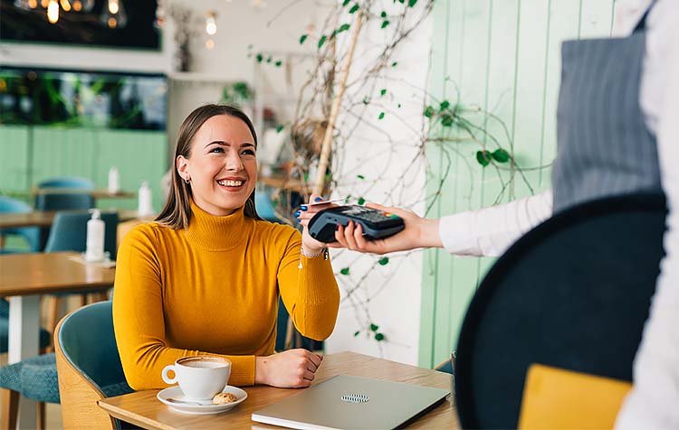 Woman paying at cafe with tap-to-pay card