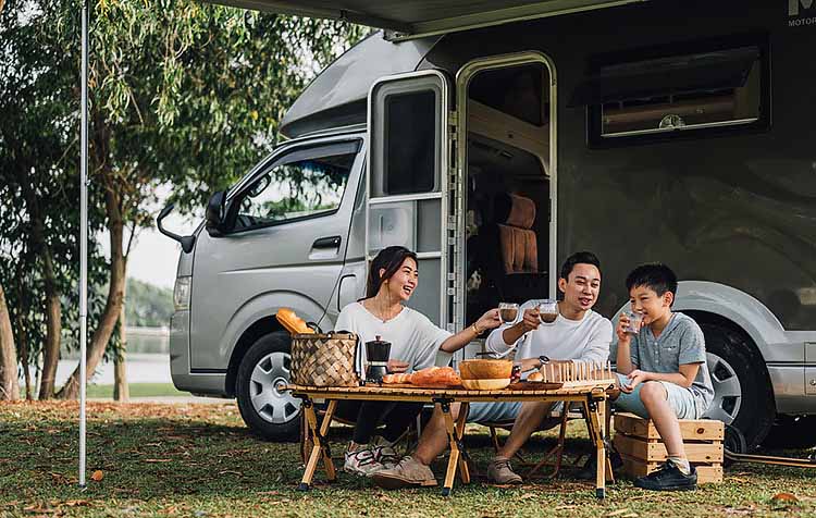 Family sitting outside RV