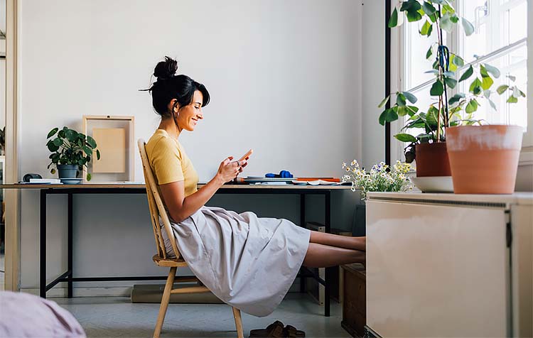 Happy woman on her phone enrolling in overdraft protection